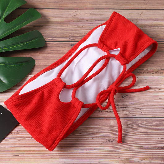 Pink ribbed bandeau bikini set with tie-back straps and high-cut bottoms on a light wooden surface. - Image 12