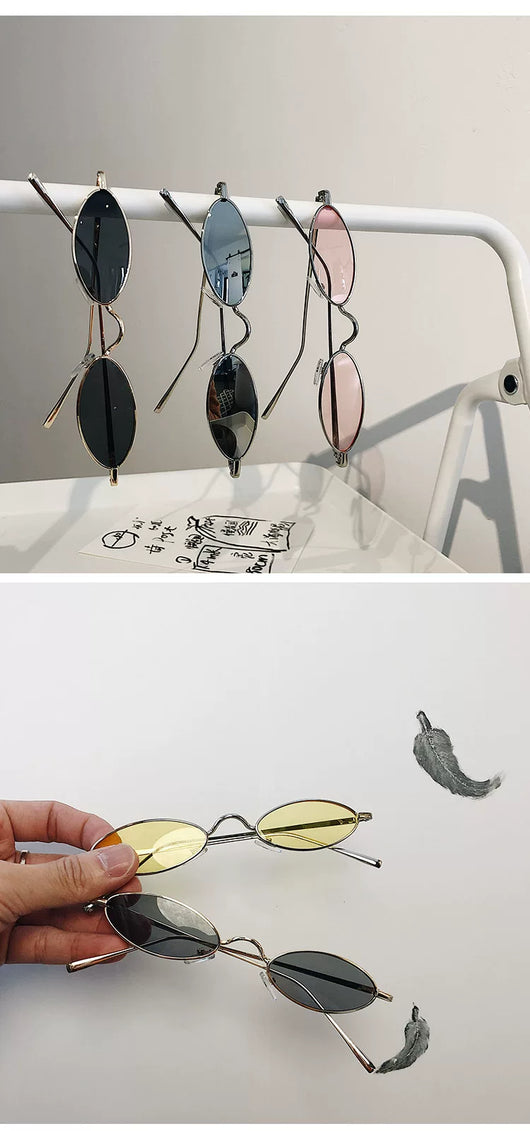 Silver-framed oval sunglasses with dark lenses reflecting a warm-toned object, displayed on a white tray. - Image 12