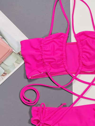 Neon pink lace-up bikini with a bandeau top and high-cut bottom, laid flat on a split gray and white background. - Image 9