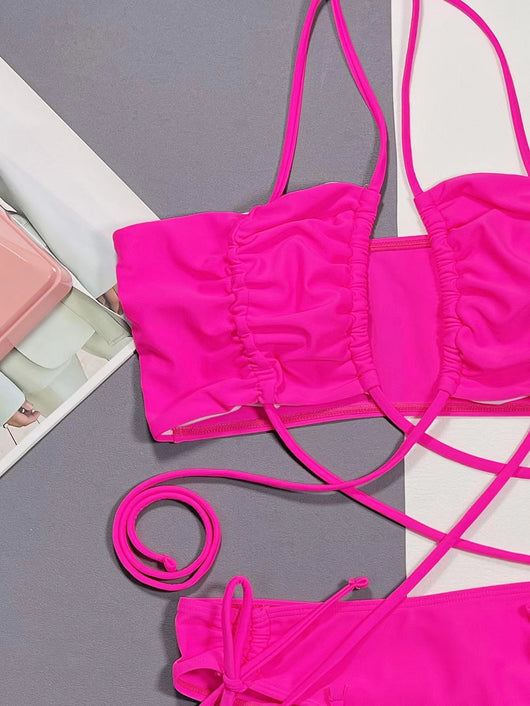 Neon pink lace-up bikini with a bandeau top and high-cut bottom, laid flat on a split gray and white background. - Image 9