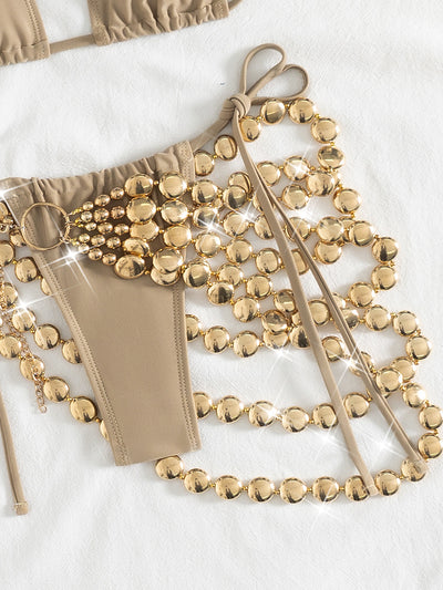 Copper halter bikini top and bottom with a gold beaded skirt, laid flat with sunglasses, seashell, and flowers. - Image 28