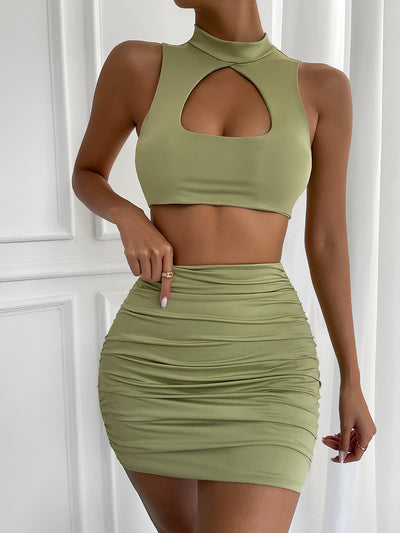 Light green two-piece set featuring a sleeveless crop top with a high neck and chest cutout, paired with a ruched bodycon mini skirt. - Image 7