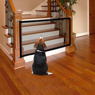 Black mesh pet gate installed at the bottom of a wooden staircase, with a golden retriever sitting in front. - Image 12