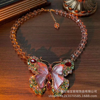 Pink enamel butterfly brooch with green, red, and clear rhinestones set in gold-toned metal. - Image 9
