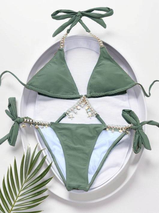 Olive green split bikini with gold chain and charm embellishments, worn with a sheer white cover-up on a beach. - Image 14