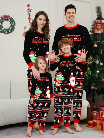 Man wearing black Christmas pajamas with a cartoon dinosaur, Santa Claus, and "Merry Christmas" text, standing by a decorated tree. - Image 25