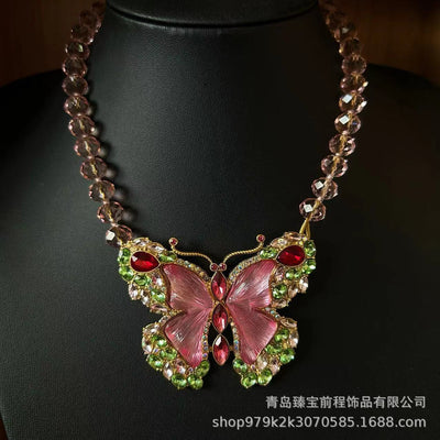 Pink enamel butterfly brooch with green, red, and clear rhinestones set in gold-toned metal. - Image 7