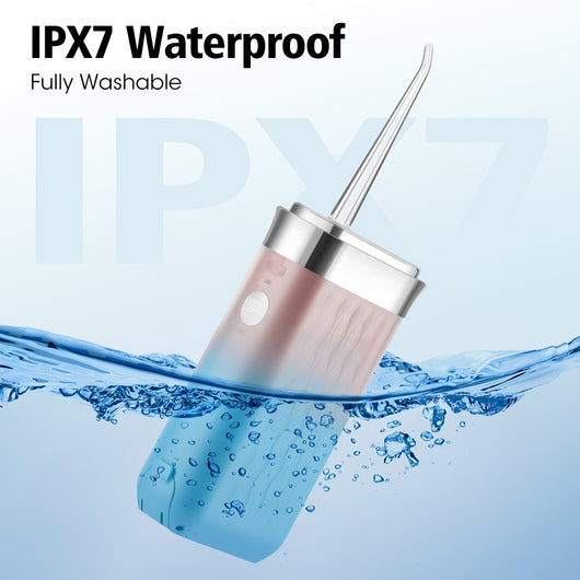Portable water flosser in gradient pink and blue with four nozzles, a charging cable, and its product box. - Image 24