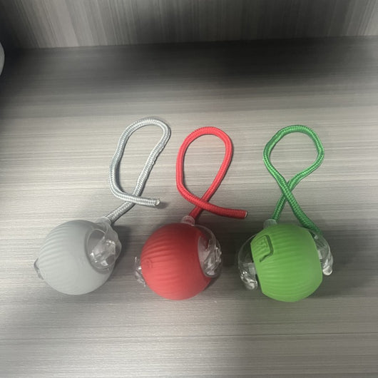 Gray intelligent automatic cat teasing ball with a clear section and braided cord, next to its white product box. - Image 11