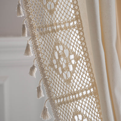 Close-up of a beige semi-transparent curtain with a delicate crochet lace trim and decorative tassels. - Image 26
