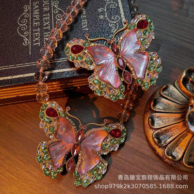 Pink enamel butterfly brooch with green, red, and clear rhinestones set in gold-toned metal. - Image 13