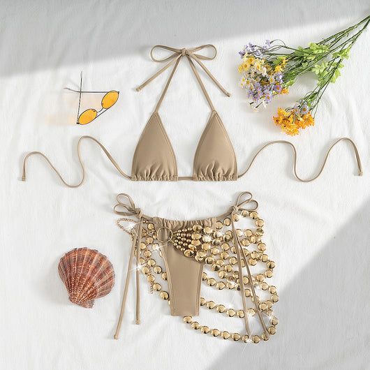 Copper halter bikini top and bottom with a gold beaded skirt, laid flat with sunglasses, seashell, and flowers. - Image 16