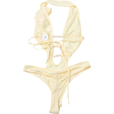 White halter monokini with deep V-neck, side cut-outs, and pearl bead embellishments on a woman at the beach. - Image 36