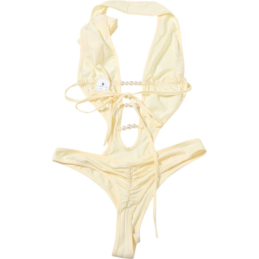 White halter monokini with deep V-neck, side cut-outs, and pearl bead embellishments on a woman at the beach. - Image 36