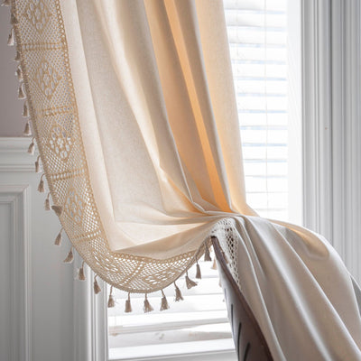 Close-up of a beige semi-transparent curtain with a delicate crochet lace trim and decorative tassels. - Image 34