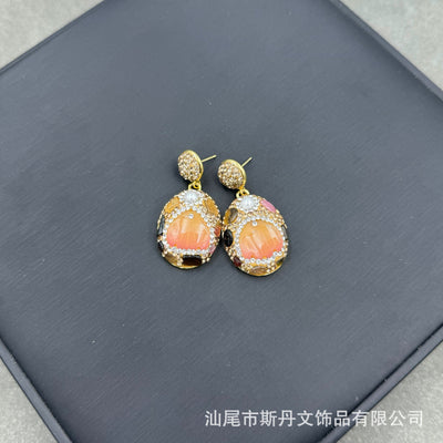 Gold-toned dangle earrings with oval drops, featuring a carved pink flower, clear rhinestones, and multi-colored tourmaline. - Image 8