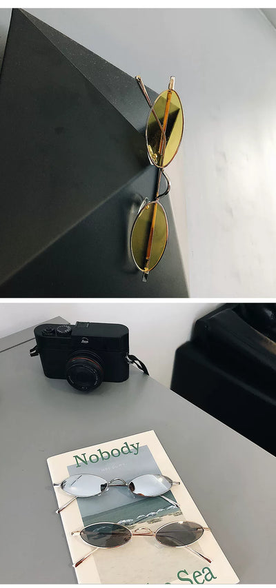 Silver-framed oval sunglasses with dark lenses reflecting a warm-toned object, displayed on a white tray. - Image 16
