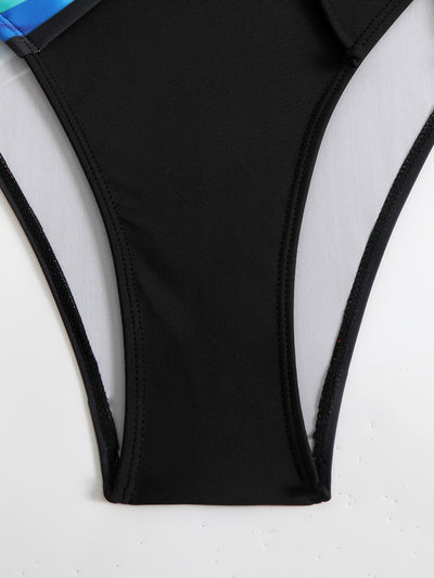 Woman in a navy and white striped tankini swimsuit with a wrap-front and side drawstring, holding a woven bag. - Image 30