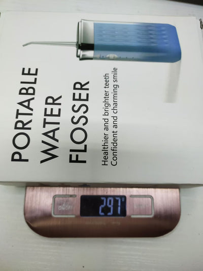 Portable water flosser in gradient pink and blue with four nozzles, a charging cable, and its product box. - Image 26