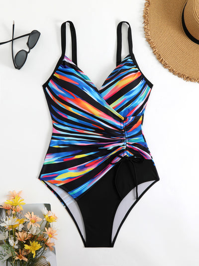 Woman in a navy and white striped tankini swimsuit with a wrap-front and side drawstring, holding a woven bag. - Image 22