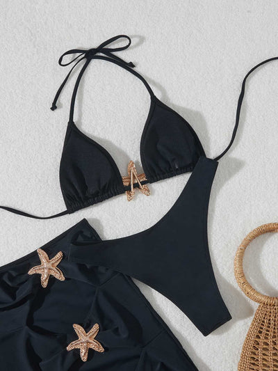 Black three-piece bikini set with triangle top, thong bottom, and skirt, all featuring gold starfish embellishments. - Image 19