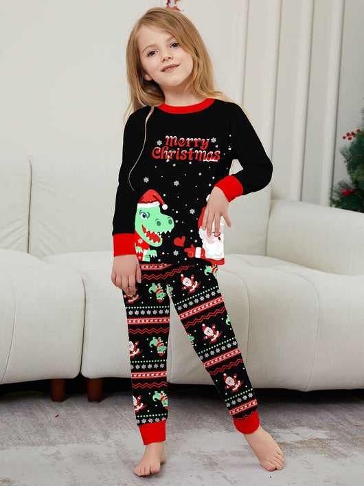 Man wearing black Christmas pajamas with a cartoon dinosaur, Santa Claus, and "Merry Christmas" text, standing by a decorated tree. - Image 35