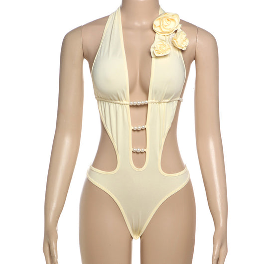 White halter monokini with deep V-neck, side cut-outs, and pearl bead embellishments on a woman at the beach. - Image 62