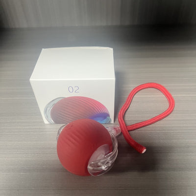 Gray intelligent automatic cat teasing ball with a clear section and braided cord, next to its white product box. - Image 9