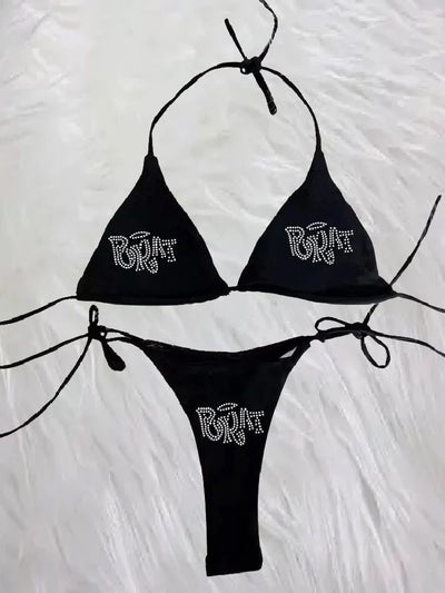 Black halter bikini with rhinestone 'BRAT' lettering on triangle top and tie-side bottom, displayed on white faux fur. - Image 9