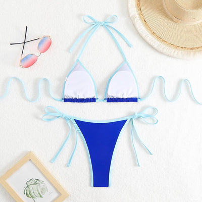 Royal blue two-piece bikini with light blue trim and tie straps, laid flat on a white textured surface. - Image 18