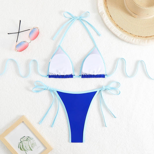 Royal blue two-piece bikini with light blue trim and tie straps, laid flat on a white textured surface. - Image 18