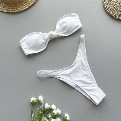 Woman wearing a black bandeau bikini top with a front knot and matching high-cut bottoms, accessorized with gold jewelry. - Image 23