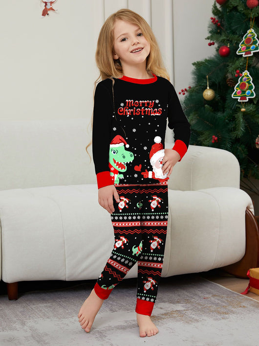 Man wearing black Christmas pajamas with a cartoon dinosaur, Santa Claus, and "Merry Christmas" text, standing by a decorated tree. - Image 29