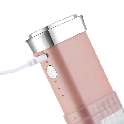 Portable water flosser in gradient pink and blue with four nozzles, a charging cable, and its product box. - Image 18
