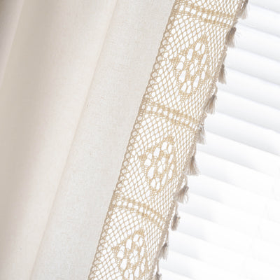 Close-up of a beige semi-transparent curtain with a delicate crochet lace trim and decorative tassels. - Image 28