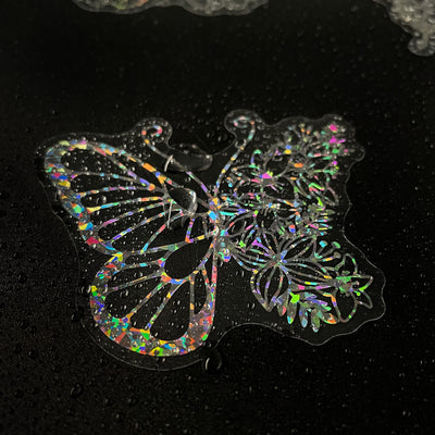 Transparent holographic butterfly laser stickers in various designs, including floral and moon elements, shown individually and in a 100-sheet pack. - Image 13