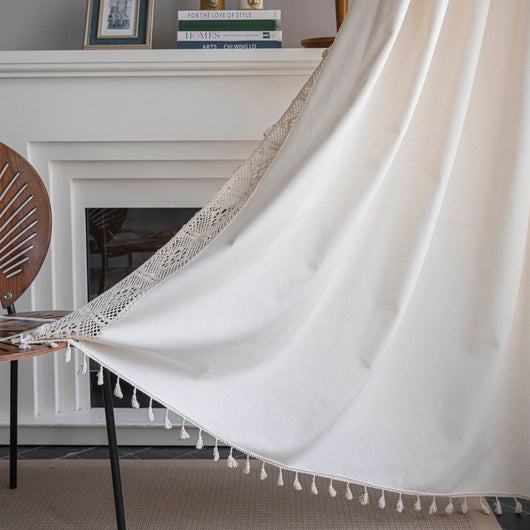 Close-up of a beige semi-transparent curtain with a delicate crochet lace trim and decorative tassels. - Image 19