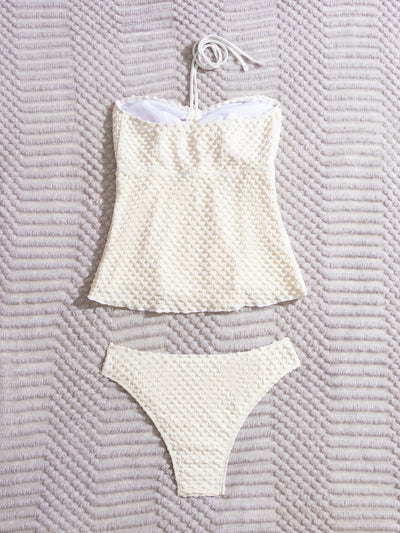 Off-white textured two-piece women's swimsuit with a bandeau halter top and high-cut bottoms, displayed with a straw hat and sunglasses. - Image 10