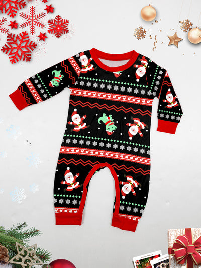 Man wearing black Christmas pajamas with a cartoon dinosaur, Santa Claus, and "Merry Christmas" text, standing by a decorated tree. - Image 33