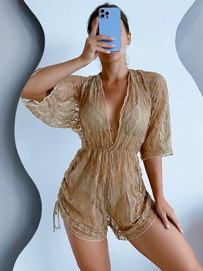 Woman wearing a white and black tie-dye beach cover-up romper with a deep V-neck and drawstring sides. - Image 24