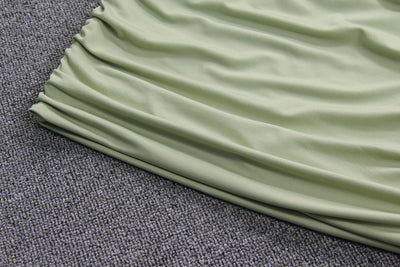 Light green two-piece set featuring a sleeveless crop top with a high neck and chest cutout, paired with a ruched bodycon mini skirt. - Image 13