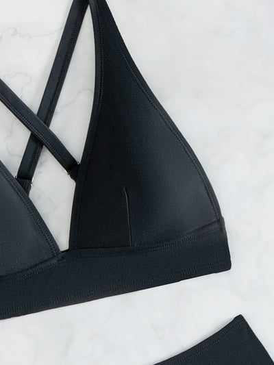 Bright blue two-piece bikini with a V-neck halter top and high-cut bottoms on a woman at the beach. - Image 30