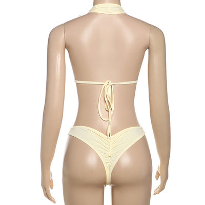White halter monokini with deep V-neck, side cut-outs, and pearl bead embellishments on a woman at the beach. - Image 50
