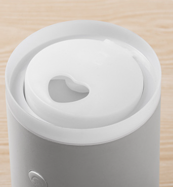 Porcelain white cylindrical humidifier emitting jellyfish-shaped mist, sitting on a round base against a split teal and dark green background. - Image 16