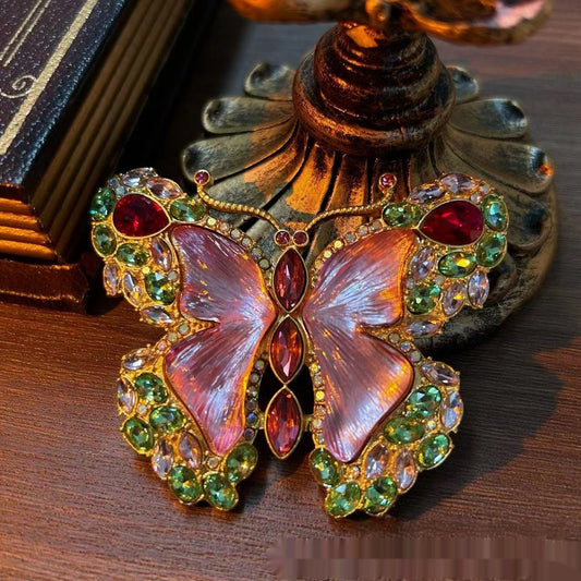 Pink enamel butterfly brooch with green, red, and clear rhinestones set in gold-toned metal. - Image 2