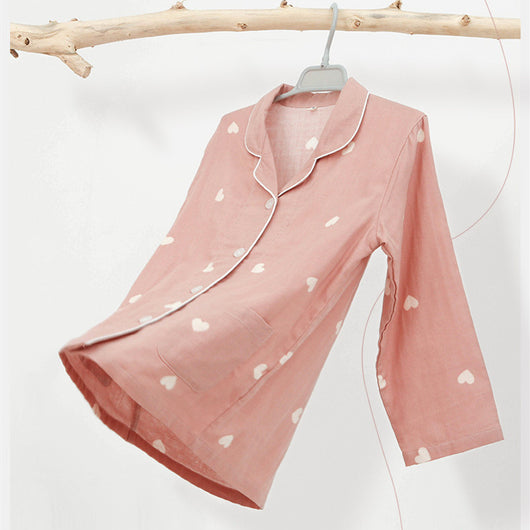 Pink long-sleeved pajama set for children with an all-over cherry print, Peter Pan collar, and matching pants.