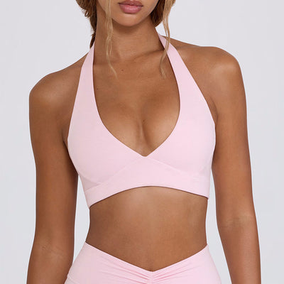 Light pink halter neck sports bra and high-waisted leggings workout set on a model. - Image 7