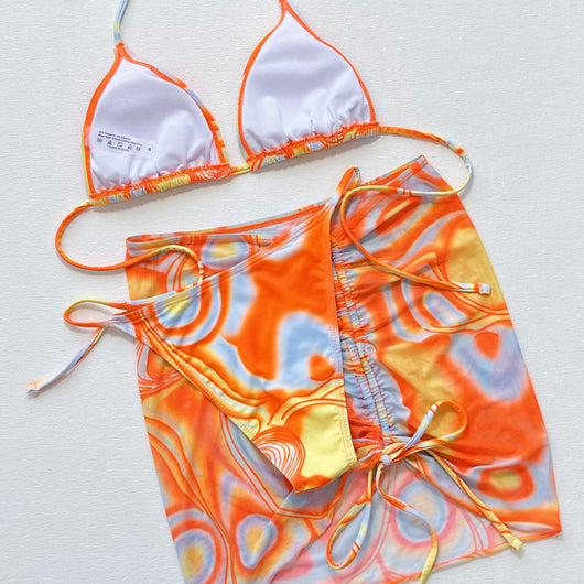 Women's three-piece swimsuit with orange, yellow, and blue abstract swirl pattern. Includes a triangle bikini top, tie-side bottom, and matching ruched sarong s - Image 5