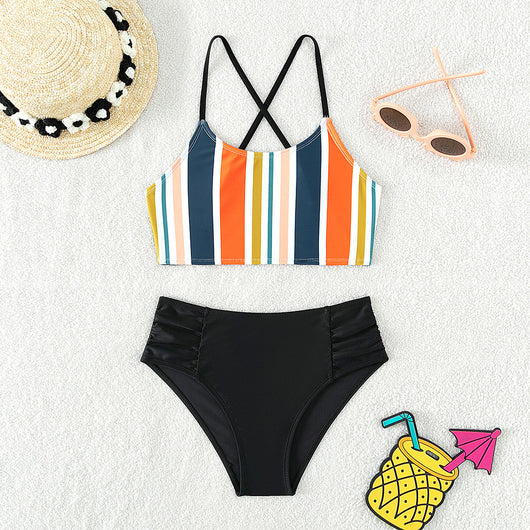 Girls' two-piece bikini swimsuit with a colorful striped crop top and solid black high-waisted ruched bottoms.