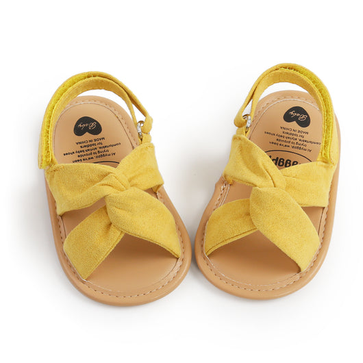 Black baby sandals with knotted cross straps and a matching black floral headband on a white background. - Image 32